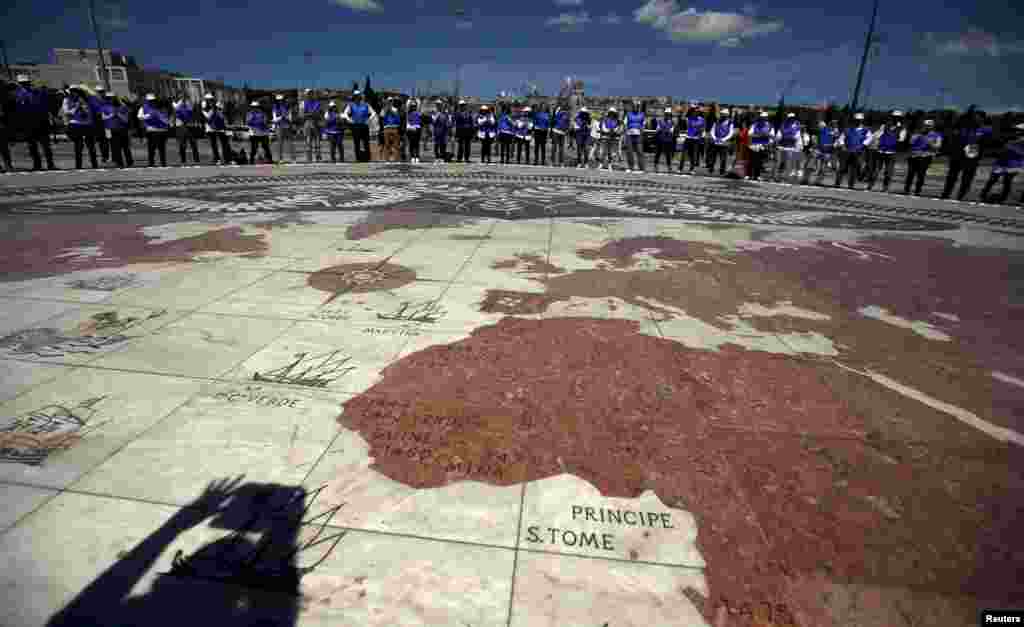Sekelompok sukarelawan berkumpul di lapangan yang dilukis peta dunia raksasa dalam peringatan Hari Bumi di Lisbon, Portugal, 22 April 2015.