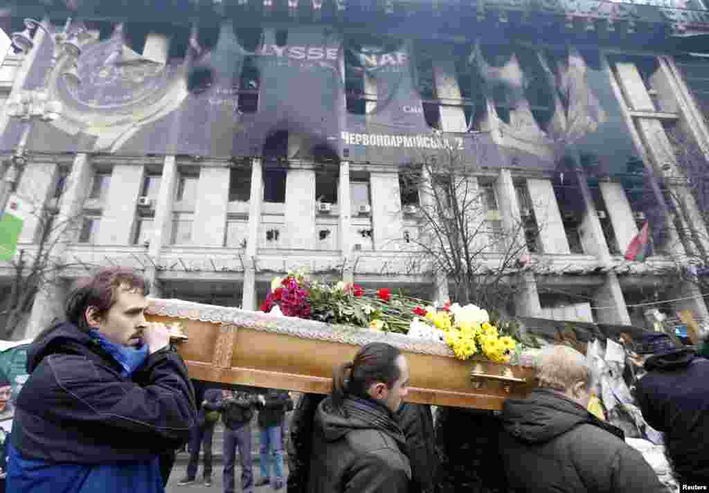 Warga menggotong peti jenazah seorang demonstran, yang terbunuh dalam sebuah aksi kekerasan, dalam sebuah upacara pemakaman di Kyiv.