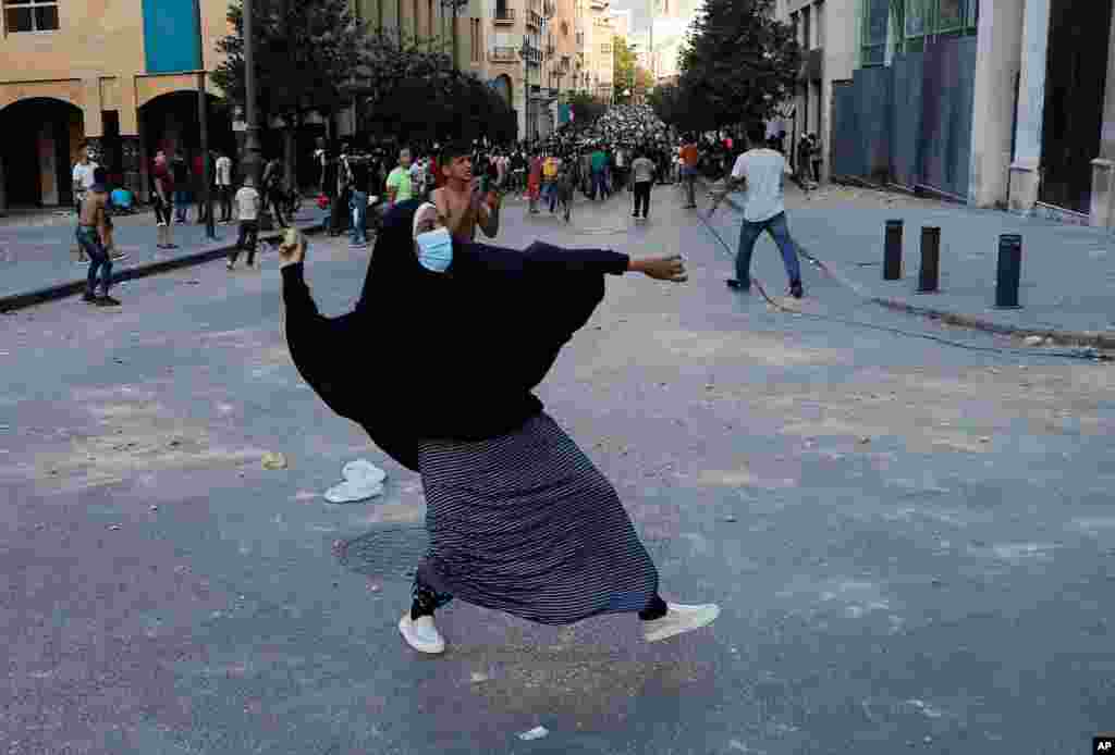 레바논 베이루트에서 대형 폭발 참사 이후 반정부 시위가 계속되는 가운데 시위에 참가한 수녀가 돌을 던지고 있다.