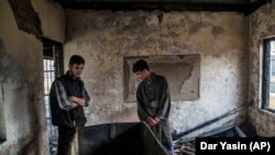 Kashmiri Muslim students inspect the damage of a partially burned government high school in Goripora, outside of Srinagar, India controlled Kashmir.