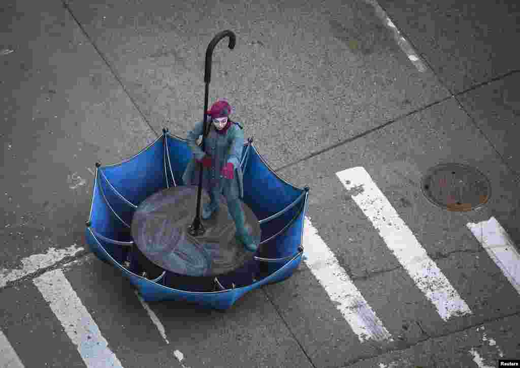 A woman in an upside-down umbrella float makes her way down 6th Ave. during the 87th Macy&#39;s Thanksgiving day parade in New York.