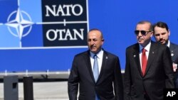 FILE - Turkish President Recep Tayyip Erdogan, right, and Foreign Minister Mevlut Cavusoglu arrive for a NATO summit in Brussels< Belgium, May 25, 2017.