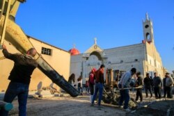 Workers repair a damaged street near the Grand Immaculate Church, ahead of the planned visit of Pope Francis to Iraq, in Qaraqosh, Iraq, Feb. 22, 2021.