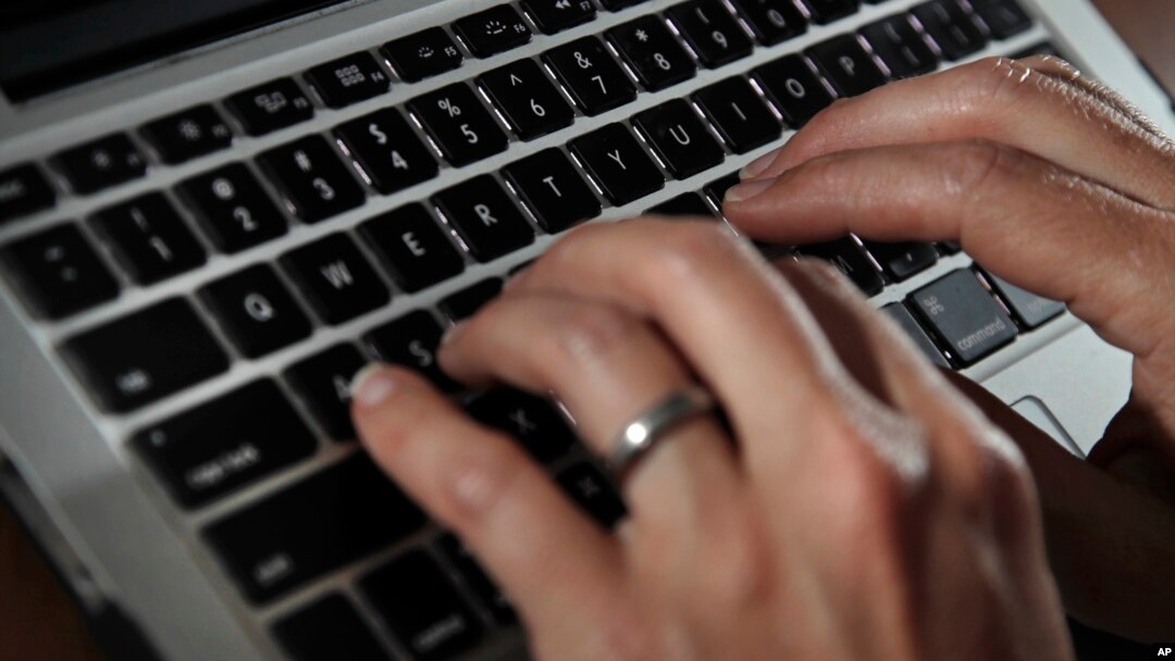 FILE- A person types on a laptop keyboard in North Andover, Mass, June 19, 2017. 