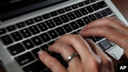 FILE - A person types on a laptop keyboard in North Andover, Mass., June 19, 2017.