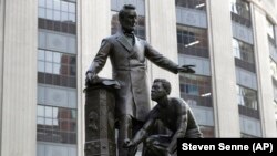 Patung yang menggambarkan budak yang dibebaskan berlutut di hadapan Presiden Abraham Lincoln, di Boston, 25 Juni 2020. (Foto: AP)