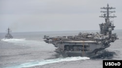 FILE - Ships assigned to the Nimitz Carrier Strike Group participate in a strait transit exercise in the Pacific Ocean in this April 3, 2017 photo.
