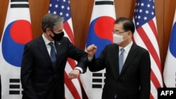 US Secretary of State Antony Blinken (L) bumps elbows with South Korean Foreign Minister Chung Eui-yong after an initialing ceremony for Special Measures Agreement at the Foreign Ministry in Seoul on March 18, 2021. (Photo by Lee Jin-man / POOL /…