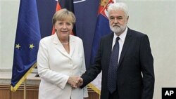German Chancellor Angela Merkel (L) shakes hands with Mirko Cvetkovic, the Serbian Prime Minister, during an official visit, in Belgrade, Serbia, August 23, 2011