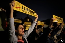 Afuera de la Corte Nacional en Madrid, personas levantan "esteladas" o banderas de la independencia de Cataluña en apoyo a los exmiembros del gobierno regional ordenados a permanecer detenidos por posibles cargos de rebelión, Nov. 2, 2017.