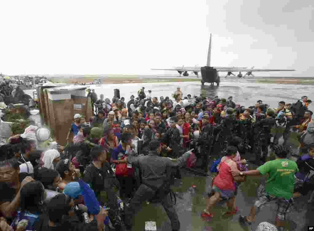 Typhoon survivors rush to get a chance to board a C-130 military transport plane in Tacloban city, Leyte province, central Philippines, Nov. 12, 2013.