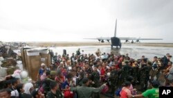 Typhoon survivors rush to get a chance to board a C-130 military transport plane in Tacloban city, Leyte province, central Philippines, Nov. 12, 2013.