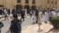 FILE - Security forces, officials and civilians gather outside of the Imam Sadiq Mosque after a deadly blast struck after Friday prayers in Kuwait City, Kuwait, June 26, 2015. 
