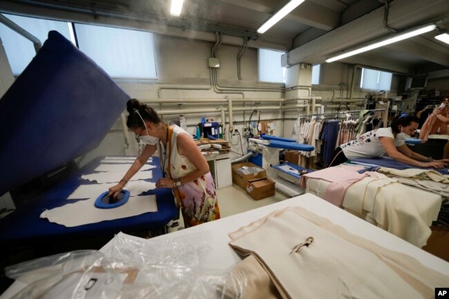 Workers iron clothes at the Cose di Maglia factory where the D.Exterior brand is produced, in Brescia, Italy on June 14, 2022. (AP Photo/Luca Bruno)