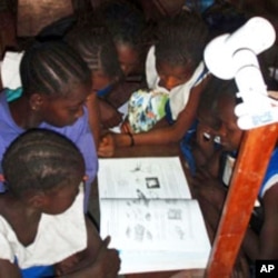 Girls in Sierra Leone read by the light of a single watt LED