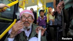 Passengers board a bus awaiting evacuation from the besieged Damascus suburb of Daraya, Aug. 26, 2016, following an agreement between rebels and Syria's government.