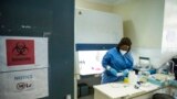 FILE - A laboratory specialist secures samples taken from potential coronavirus patients in Juba, South Sudan, June 19, 2020.