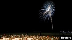 Miles de personas recuerdan con velas y fuegos artificiales el décimo aniversario del terremoto y sunami en el noreste de Japón, el 11 de marzo de 2021.