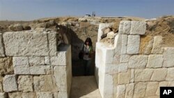 A journalist walks through the entrance of the newly discovered tomb of Rudj Ka, a priest who headed the mortuary cult of the pharaoh Khafra, near the Giza Pyramids in Cairo, Egypt, 19 Oct 2010