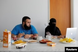 Meryem, 20, a wearer of the niqab and a member of the group Kvinder I Dialog (Women in Dialogue), sits with her husband Ali, 23, as she updates her blog Niqabi Nuancer over a vegan breakfast in Aarhus, Denmark, July 28, 2018.