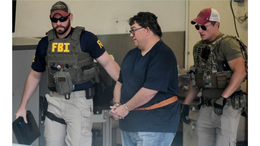 FBI agents escort businessman Fernando Scherrer-Caillet who was arrested in San Juan, Puerto Rico, July 10, 2019.