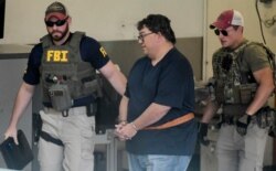 FBI agents escort businessman Fernando Scherrer-Caillet who was arrested in San Juan, Puerto Rico, July 10, 2019.
