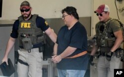 FBI agents escort businessman Fernando Scherrer-Caillet who was arrested in San Juan, Puerto Rico, July 10, 2019.