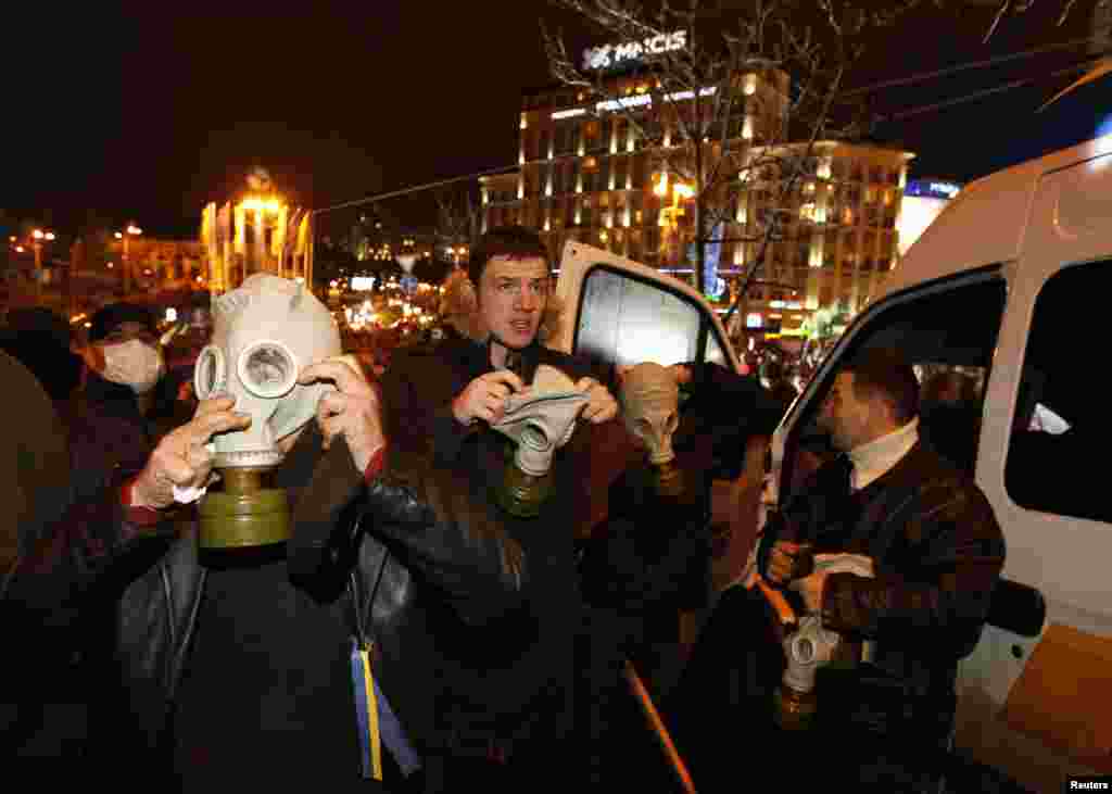 Protesters wear gas masks during a demonstration to support EU integration in Kyiv, Nov. 25, 2013. 