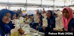 Sejumlah mahasiswi Universitas Surabaya sedang mengerjakan pembuatan wayang kartas (karton) Punakawan (Foto: VOA/ Petrus Riski).