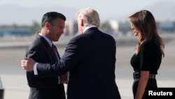 U.S. President Donald Trump and first lady Melania Trump are greeted by Nevada Governor Brian Sandoval as they arrive to meet with officials and first responders in the wake of the mass shooting in Las Vegas, Nevada, Oct. 4, 2017. 