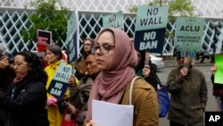 Isra Ayesh, center, of Seattle, who is the organizing director of Americans for Refugees and Immigrants, waits for her turn to speak during a demonstration against President Donald Trump's revised travel ban outside a federal courthouse in Seattle, May 15, 2017.
