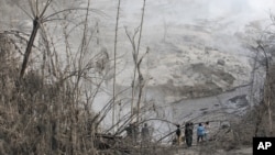 Жители деревни Гамбер наблюдают за последствиями извержения вулкана Синабург. Индонезия. 22 мая 2016 г.