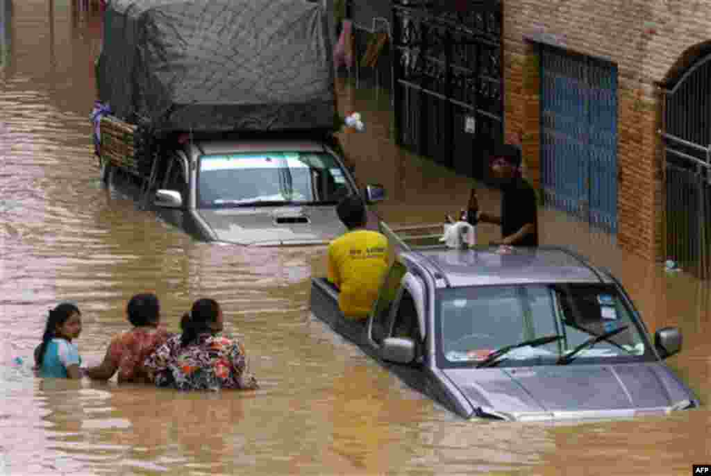 Residents wade through flood waters in down town Hat Yai of Songkhla province, southern Thailand Wednesday, Nov. 3, 2010. Thailand rushed soldiers and its only aircraft carrier to rescue residents in a key southern city submerged by the latest flooding. (