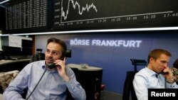 Traders work in front of the German share price index DAX board, at the stock exchange in Frankfurt, Germany, Nov. 4, 2015.