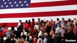 FILE - People turn to face a U.S. flag during the playing of the national anthem before U.S. President Donald Trump rallies with supporters during a Make America Great Again rally in Southaven, Mississippi, U.S. Oct. 2, 2018. 