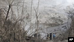 Dân làng đứng xem đường đi của dòng nham thạch từ núi lửa phun trào của núi Sinabung ở làng Gamber, Bắc Sumatra, Indonesia, ngày 22/5/2016.