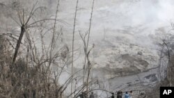 Penduduk desa mengamati jalur aliran awan panas dari letusan Gunung Sinabung. Desa Gamber, Sumut (AP Photo/Binsar Bakkara)