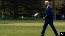 FILE - President Joe Biden walks to board Marine One on the South Lawn of the White House for a trip, in Washington, Nov. 30, 2021. 