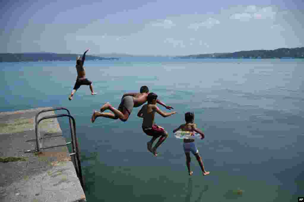 Anak-anak melompat ke laut di Selat Bosphorus di kota Istanbul, Turki.