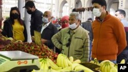 Des habitants portant des masques font leurs courses pour le Ramadan à Tunis, le jeudi 23 avril 2020.