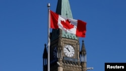 资料照片：加拿大国旗在渥太华国会山和平塔前飘扬