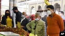 Warga Tunisia berbelanja kebutuhan menjelang bulan suci Ramadan dengan mengenakan masker, di tengah pandemi COVID-19, 23 April 2020. (AP Photo/Hassene Dridi)