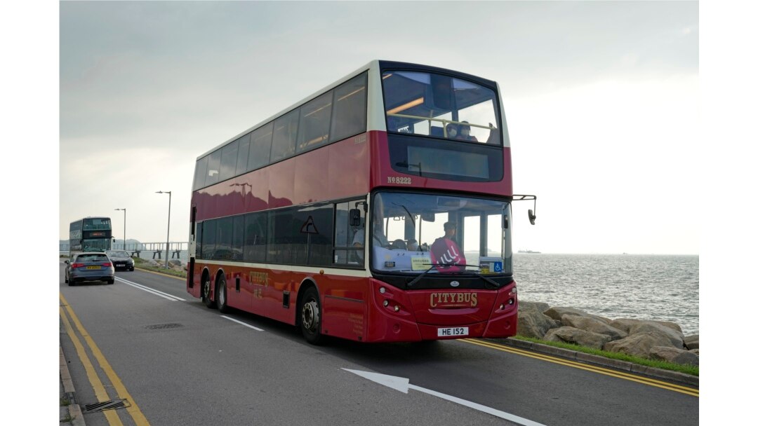 Sebuah bus tingkat melintas di jalan tepi laut dekat bandara di Hong Kong, Sabtu, 16 Oktober 2021. Bagi warga yang merindukan kegiatan bepergian yang santai, sebuah agen perjalanan kini menawarkan solusinya, yakni Bus Tidur. (Foto: AP)