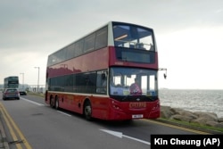 Sebuah bus tingkat melintas di jalan tepi laut dekat bandara di Hong Kong, Sabtu, 16 Oktober 2021. Perjalanan sejauh 47 mil, lima jam dengan bus tingkat di sekitar wilayah itu dimaksudkan untuk menarik orang-orang yang mudah tidur dalam perjalanan panjang