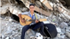 In this frame captured from video, Palestinian teenager Youssef Saad sits on the rubble of his house as he plays oud to bring joy to children, amid Israel-Hamas conflict, in Jabalia refugee camp in the northern Gaza Strip September 2, 2024. (REUTERS/Mahmoud Issa)