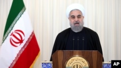 Presiden Iran Hassan Rouhani menyampaikan pidato yang ditayangkan di televisi setelah Badan Energi Atom Internasional menyetujui sebuah resolusi untuk mengakhiri penyelidikannya mengenai program nuklir Iran, di kantornya di Teheran, Iran, 16 Desember 2015. 