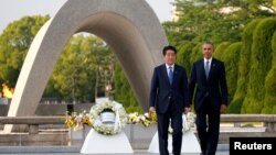 U.S. President Barack Obama (R) and Japanese Prime Minister Shinzo Abe walk in front of a cenotaph after they laid wreaths at Hiroshima Peace Memorial Park in Hiroshima, Japan, May 27, 2016.