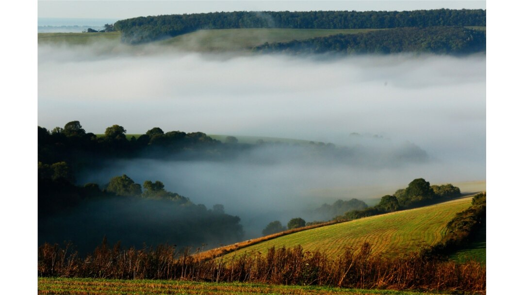 FILE - Autumn mists hang over villages and the countryside in the South Downs National Park near Amberley in Southern England.