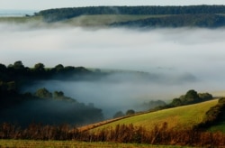 FILE - Autumn mists hang over villages and the countryside in the South Downs National Park near Amberley in Southern England.