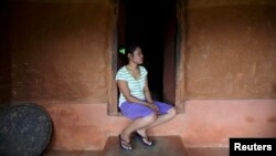 FILE - Stateless Nina Tamang, 18, is seen as she sits in the doorway of her red mud-stone hilltop home on the outskirts of Nepal's capital Katmandu, Aug. 14, 2011. 